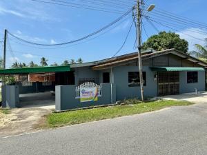 un bâtiment bleu avec un panneau sur son côté dans l'établissement Teratak Tok Ma Rumah Cengal, à Kuala Terengganu