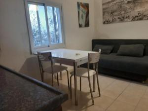 a living room with a table and chairs and a couch at הירקון 10 in Tel Aviv