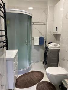 ein Bad mit einer Dusche, einem WC und einem Waschbecken in der Unterkunft Уникальная квартира в жк Амир in Almaty