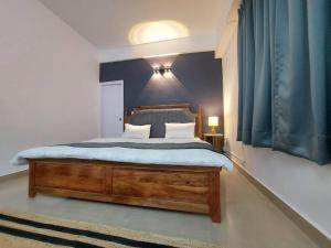 a bedroom with a wooden bed with a blue wall at Skyline 2BHK Independent flat in Lucknow