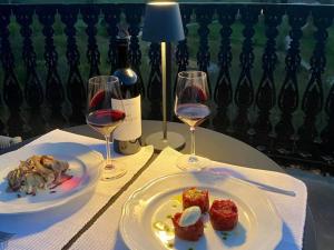Torre Veglio في Terruggia: كأسين من النبيذ وصحن من الطعام على طاولة