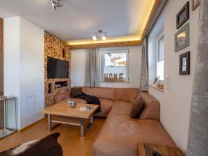 ein Wohnzimmer mit einem Sofa und einem Tisch in der Unterkunft Luxus Ferienwohnung Almhütte in Brixen im Thale