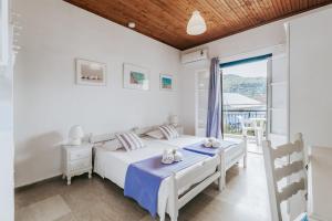 a bedroom with two beds and a window at Sunflower Apartments & Studios in Kassiopi
