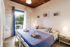 a bedroom with a bed and a large window at Sunflower Apartments & Studios in Kassiopi