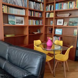 - un salon avec une table, des chaises et des étagères dans l'établissement Raibetta Apartment, à Gênes
