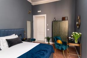 ein Schlafzimmer mit einem Bett und einem blauen Stuhl in der Unterkunft Quatrum Napoli - B&B in Neapel + 98 Fotos