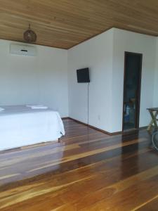 1 dormitorio con 1 cama y TV de pantalla plana en Sun Beach Chalés en Luis Correia