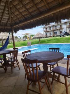 uma mesa e cadeiras em frente a uma piscina em Sun Beach Chalés em Luís Correia