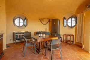 a dining room with a table and chairs and two windows at Torre Veglio in Terruggia