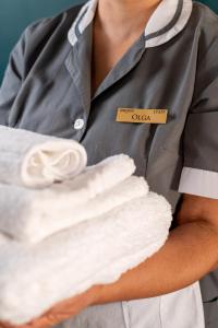 Ein Mann mit einem Haufen weißer Handtücher in der Unterkunft Quatrum Napoli - B&B in Neapel