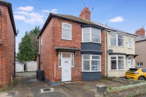 a red brick house with a white door at Elegant 4 Bedroom Near South Park Sleeps 7 in Darlington