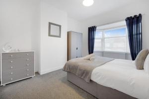 a bedroom with a large bed and a window at Elegant 4 Bedroom Near South Park Sleeps 7 in Darlington