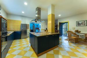 a large kitchen with blue cabinets and a checkered floor at Río y Encanto: Casona en Puente Viesgo in Puente Viesgo