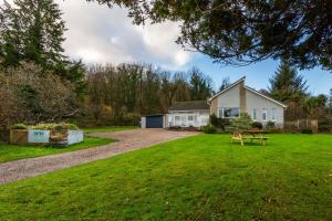 a house with a picnic table in the yard at Monamore Guest House in Lamlash