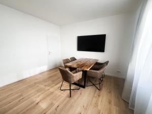 a dining room with a table and chairs and a tv at Cityapartments Düsseldorf - Stadtmitte in Düsseldorf