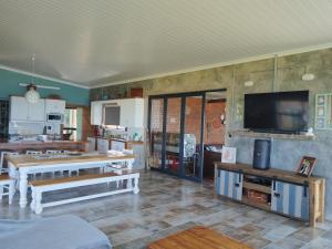 a living room with tables and a tv on the wall at Oppi Plaas See Uitsig 3 in Glentana