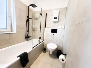 a bathroom with a toilet and a tub and a sink at Cityapartments Düsseldorf - Stadtmitte in Düsseldorf