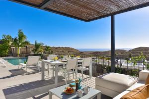 a patio with a table and chairs and a pool at Las Yucas 12 by VillaGranCanaria in Salobre