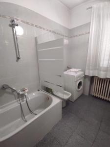 La salle de bains blanche est pourvue d'une baignoire et de toilettes. dans l'établissement Giuditta B&B, à Cirié