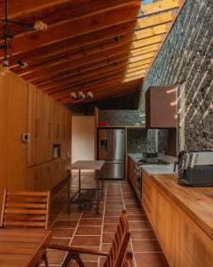 a kitchen with wooden cabinets and a table at La Hacienda Tepoztlán Awarded - Firenze Entremuros in Tepoztlán