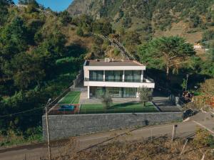 a large white house on a hill with a road at Villa Montana in São Vicente
