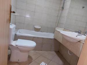 a bathroom with a toilet and a sink at TWO BEDROOM VACATION HOME AT SHARJAH DUBAI BOARDER BY MAUON.COM in Sharjah