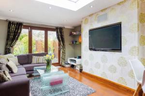 a living room with a couch and a tv on a wall at Byford Lodge Luxury self-catering in Louth in Louth