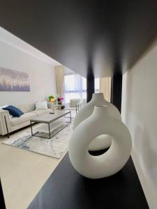 a living room with a white vase on the floor at Luxury waterview 2BD in Sharjah