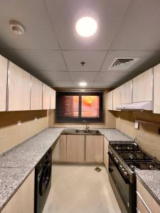 an empty kitchen with a stove and a sink at Luxury waterview 2BD in Sharjah