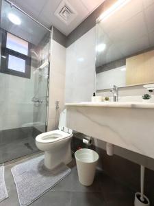 a bathroom with a toilet and a sink and a shower at Luxury waterview 2BD in Sharjah