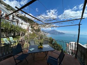 a table and chairs on a balcony with a view of the ocean at Amalfi 51 con vista mare, giardino e terrazze in Conca dei Marini