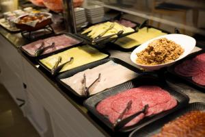 a counter topped with pans filled with different types of food at Daniya Alicante in Alicante