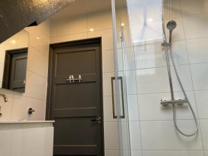 a shower with a black door in a bathroom at Bed en Breakfast Het Friesche Paard in Purmer