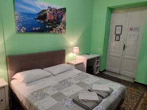a bedroom with a large bed with green walls at Albergo Locanda Alambra in Genova