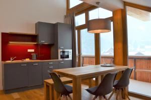 a kitchen with a wooden table and some chairs at Residence Post in Pec pod Sněžkou