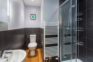 a bathroom with a toilet and a glass shower at Monamore Guest House in Lamlash