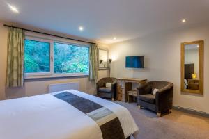 una camera d'albergo con un letto e due sedie e una scrivania di Monamore Guest House a Lamlash