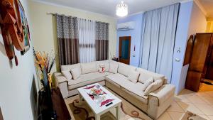 a living room with a white couch and a table at Guest House Edison in Berat
