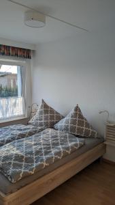 a bedroom with a bed with pillows and a window at Ferienbungalow Kajüte in Ostseebad Koserow