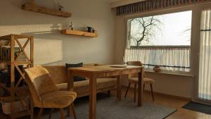 a living room with a table and chairs and a window at Ferienbungalow Kajüte in Ostseebad Koserow