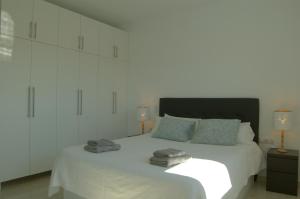 um quarto com uma cama branca e toalhas em Villa Paraíso, exclusiva, todas las comodidades em Girona