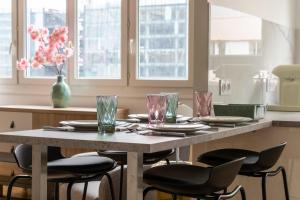 une table avec des chaises, des assiettes et des verres dans l'établissement Comfortable apartment with view - Welkeys, à Puteaux