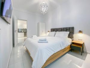 - une grande chambre blanche avec un grand lit et des draps blancs dans l'établissement Syntagma square, 55sqm Golden Suite, à Athènes