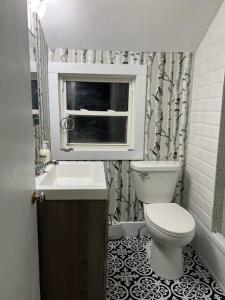 a bathroom with a toilet and a sink and a window at Sunset View in OʼLeary