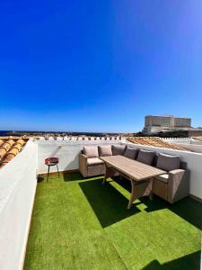 een patio met een tafel en stoelen op een dak bij Apartamento 308 Castell Sol CB in Es Mercadal
