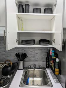 a kitchen counter with a sink and plates on a shelf at Modern One Bedroom in Union Sq - great location in New York