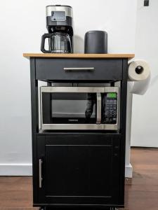 a black cabinet with a microwave on top of it at Modern One Bedroom in Union Sq - great location in New York
