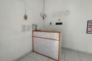 a room with a white wall and a white refrigerator at Wisma Hiro Pertiwi in Palembang