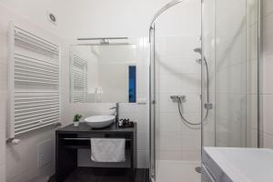 Pristine 1BR Steps from City by HM في فيينا: حمام أبيض مع حوض ودش