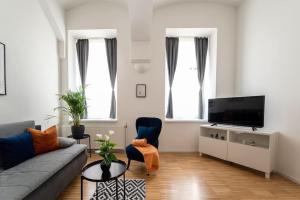 un soggiorno con divano e TV a schermo piatto di Pristine 1BR Steps from City by HM a Vienna